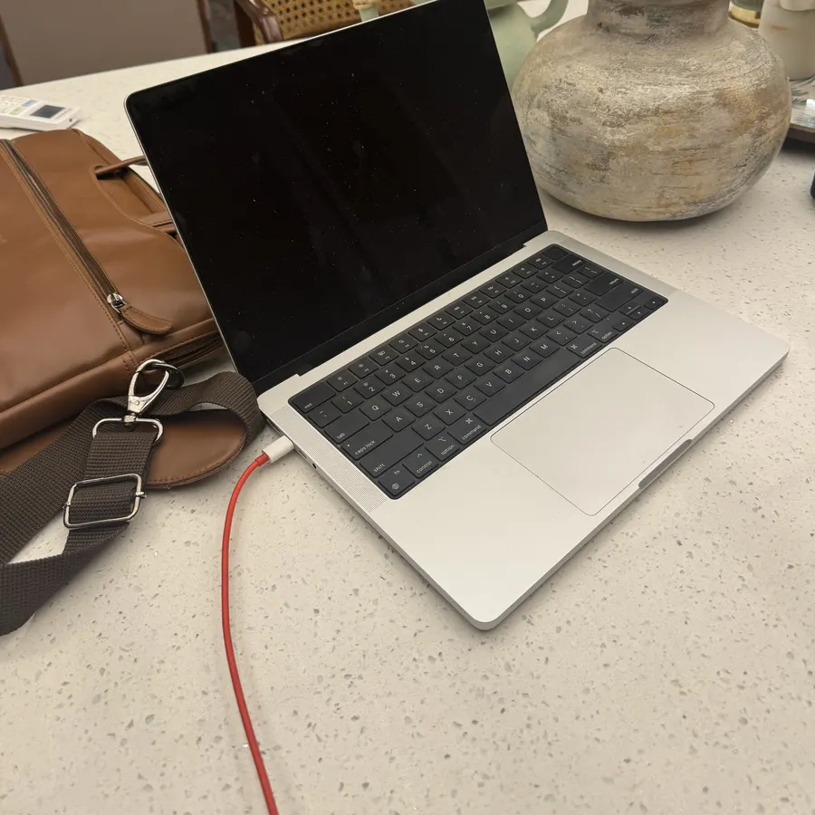 My laptop and bag on a stone counter in March 2025, away from the desk.