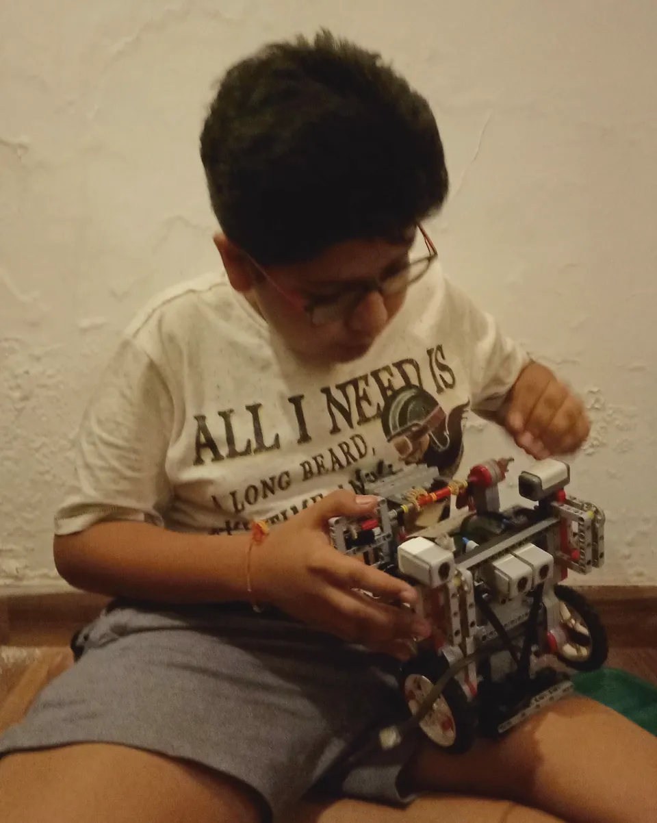 Me in August 2019, sitting on the floor and working on the robot.
